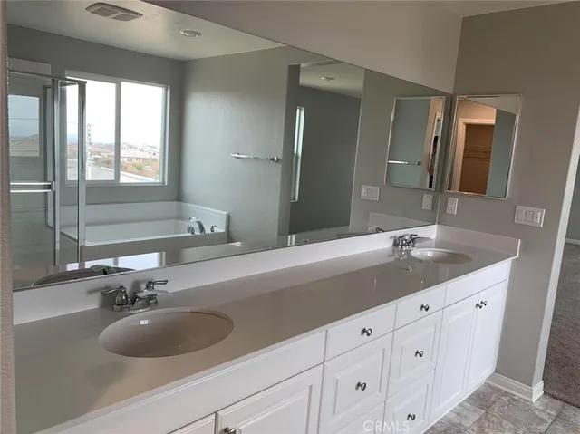 a bathroom with a sink a faucet a mirror and cabinets