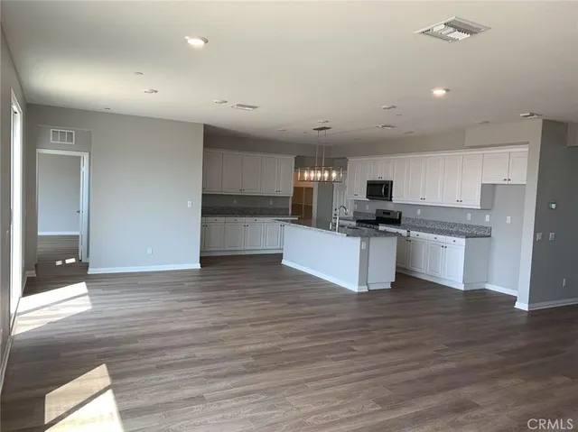 a kitchen with granite countertop a refrigerator and a stove top oven