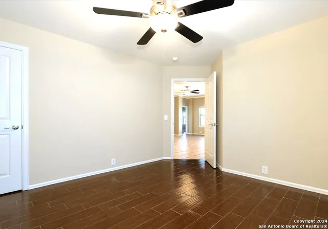 a view of an empty room with wooden floor