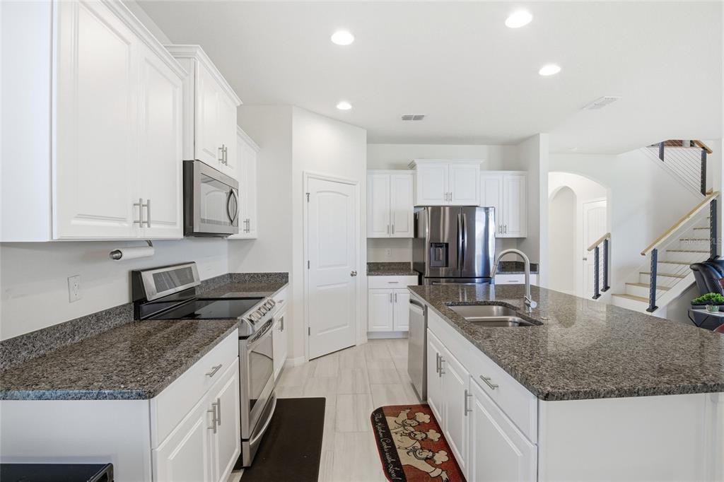 16098 Mangrove Road Winter Garden, FL 34787 - Photo 6 of 40 a kitchen with stainless steel appliances granite countertop a sink stove and refrigerator