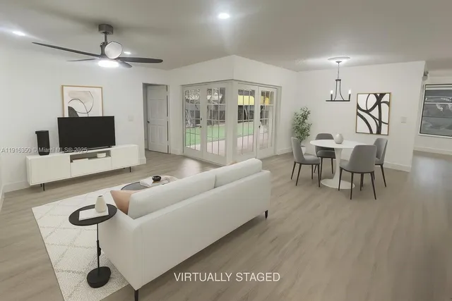 a living room with furniture a flat screen tv and a floor to ceiling window