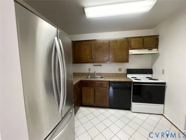 a kitchen with stainless steel appliances granite countertop a refrigerator stove and sink