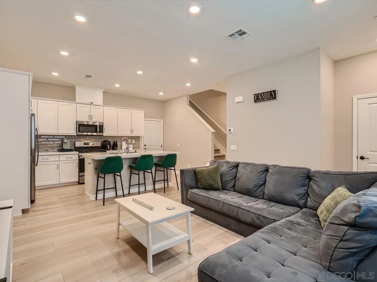 a living room with furniture and kitchen view