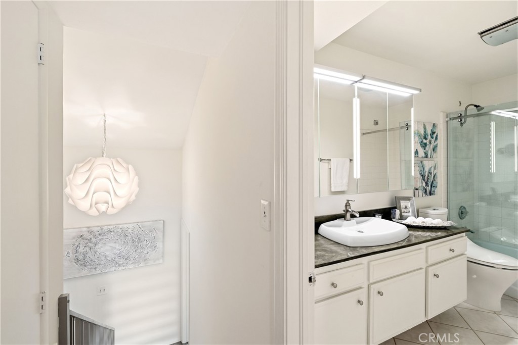 1140 Manhattan Beach, Unit D Manhattan Beach, CA 90266 - Photo 11 of 12 a bathroom with a granite countertop sink a mirror and a shower