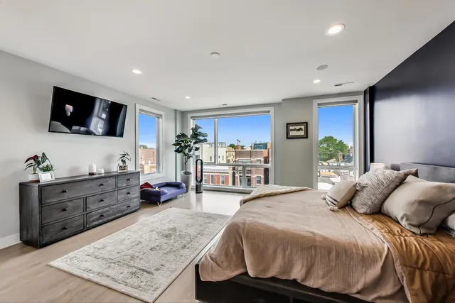 a spacious bedroom with a bed and a flat screen television