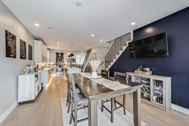 a living room with stainless steel appliances furniture and a flat screen tv