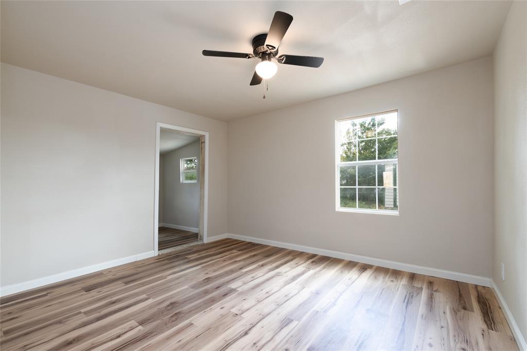 3001 Old Anson Road Abilene, TX 79603 - Photo 9 of 16 Interior room featuring wood-finish flooring, light-toned wall paint, a ceiling fan with integrated lighting, and a white-framed window