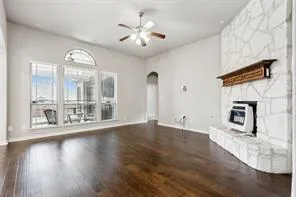 a view of a livingroom with wooden floor and a large window