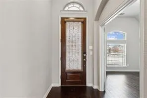a view of a hallway with wooden floor and windows