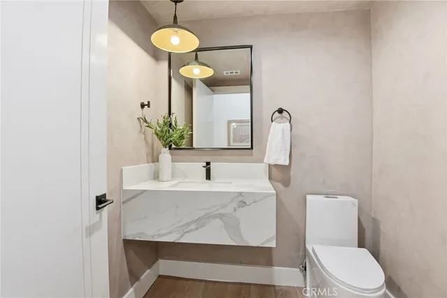 a bathroom with a toilet a sink and mirror