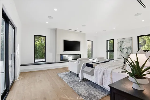 a living room with furniture a flat screen tv and a large window