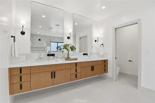 a spacious bathroom with a granite countertop double vanity sink mirror and bathtub