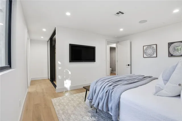 a bedroom with a bed and a flat screen tv