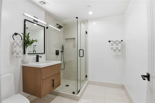 a bathroom with a sink a toilet a mirror and shower