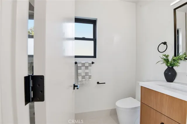 a view of bathroom with a toilet sink and mirror