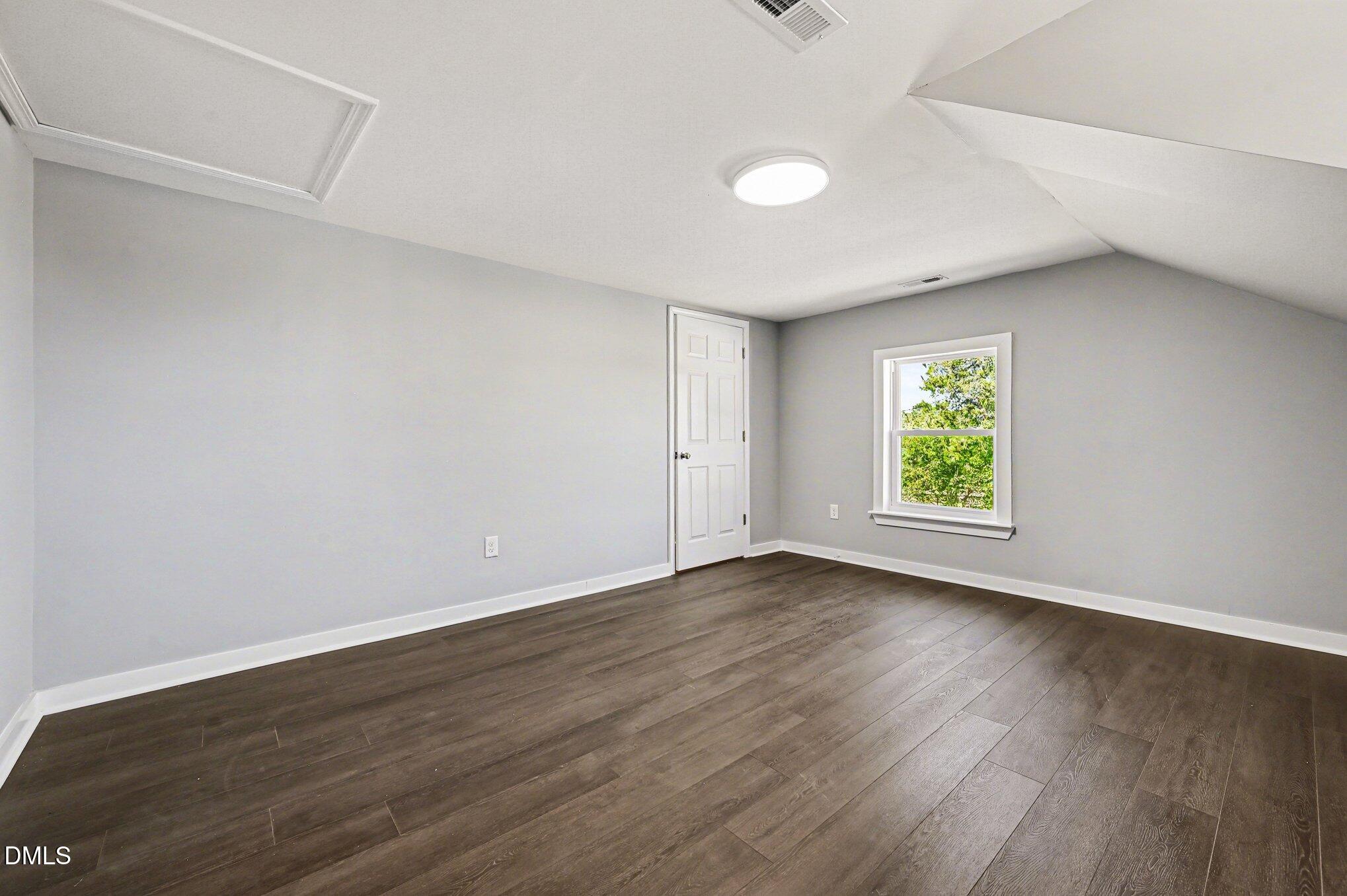 1325 Charlie Carr Road Roxboro, NC 27574 - Photo 20 of 31 an empty room with wooden floor and window
