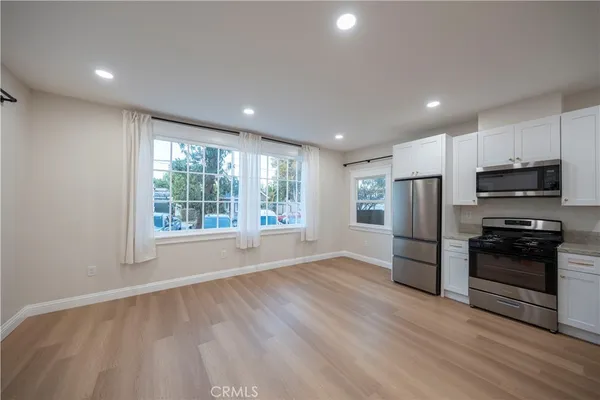 a view of kitchen with stainless steel appliances granite countertop a refrigerator and a stove top oven
