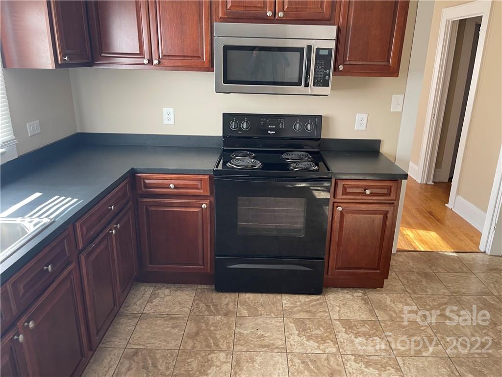 a kitchen with stainless steel appliances granite countertop a stove and a microwave