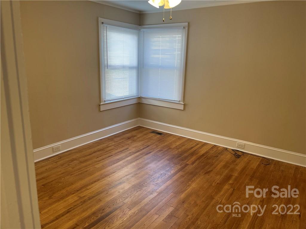 607 Salisbury Road Statesville, NC 28677 - Photo 12 of 20 an empty room with wooden floor and windows