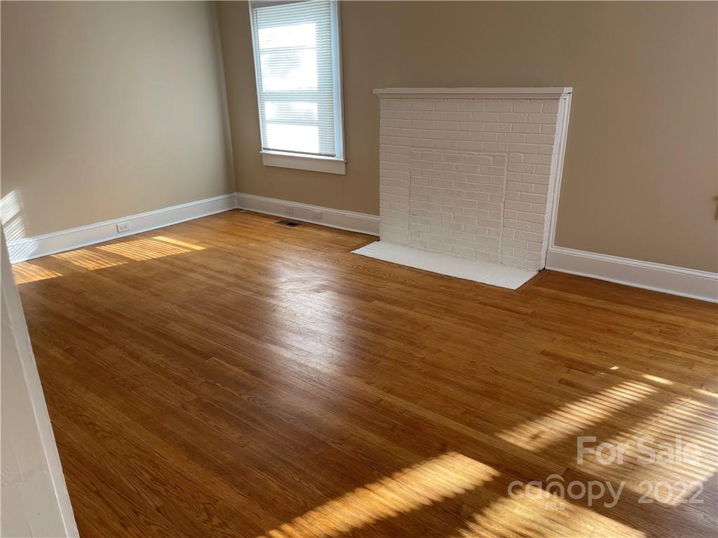 607 Salisbury Road Statesville, NC 28677 - Photo 4 of 20 an empty room with wooden floor and windows