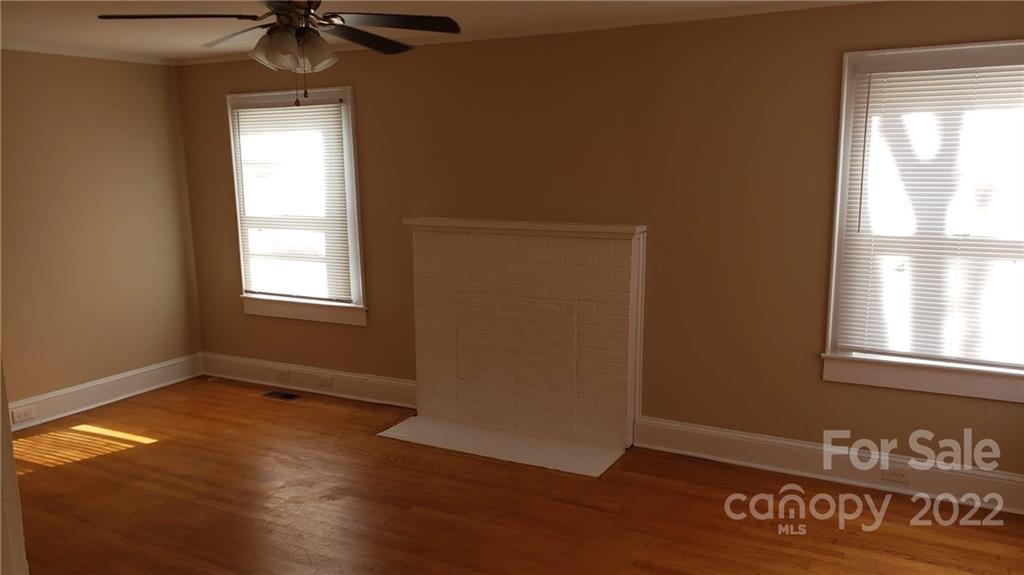 607 Salisbury Road Statesville, NC 28677 - Photo 5 of 20 an empty room with wooden floor fan and windows