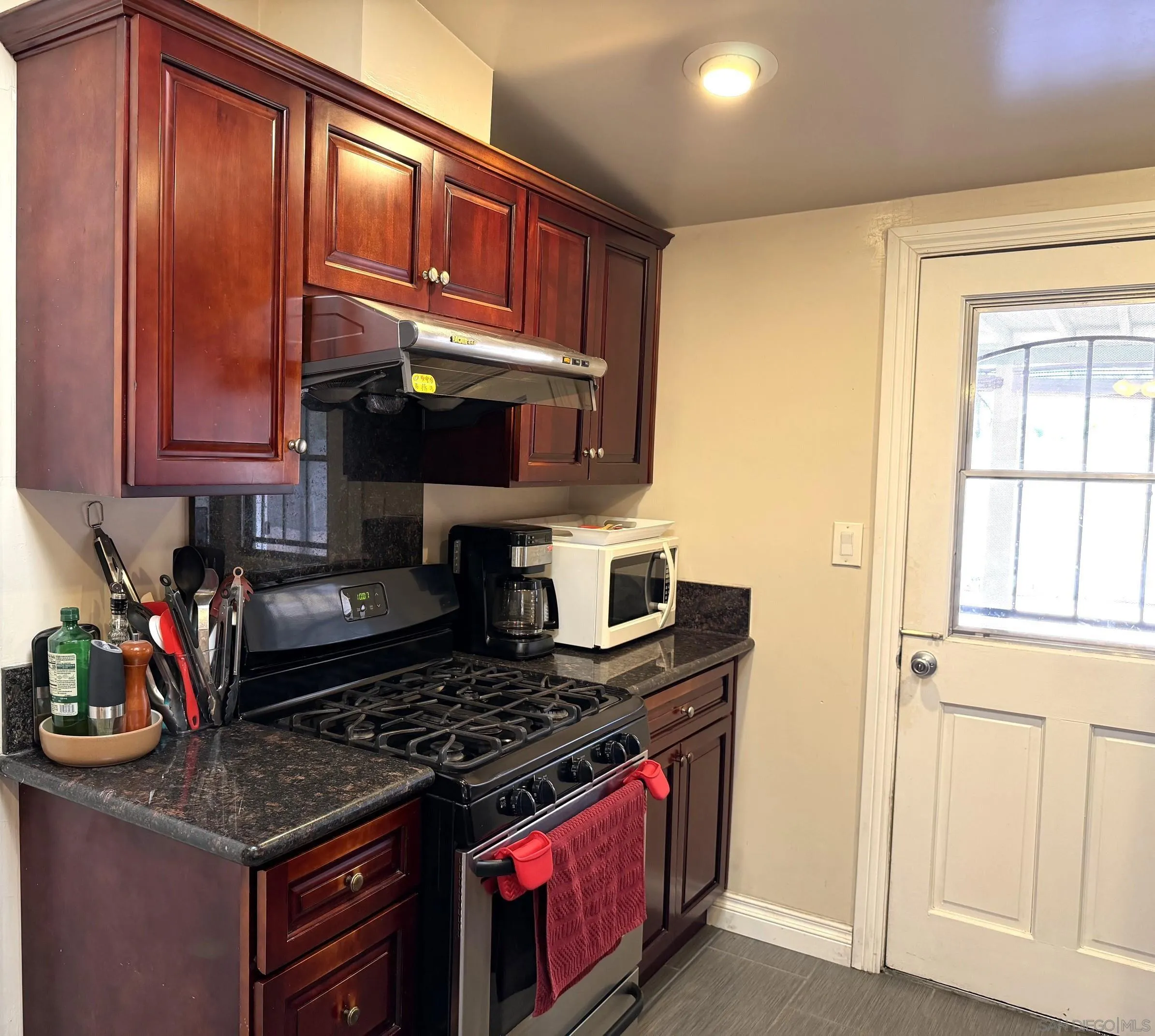 12923 Slack Street Poway, CA 92064 - Photo 11 of 29 a kitchen with stainless steel appliances granite countertop a stove and a microwave