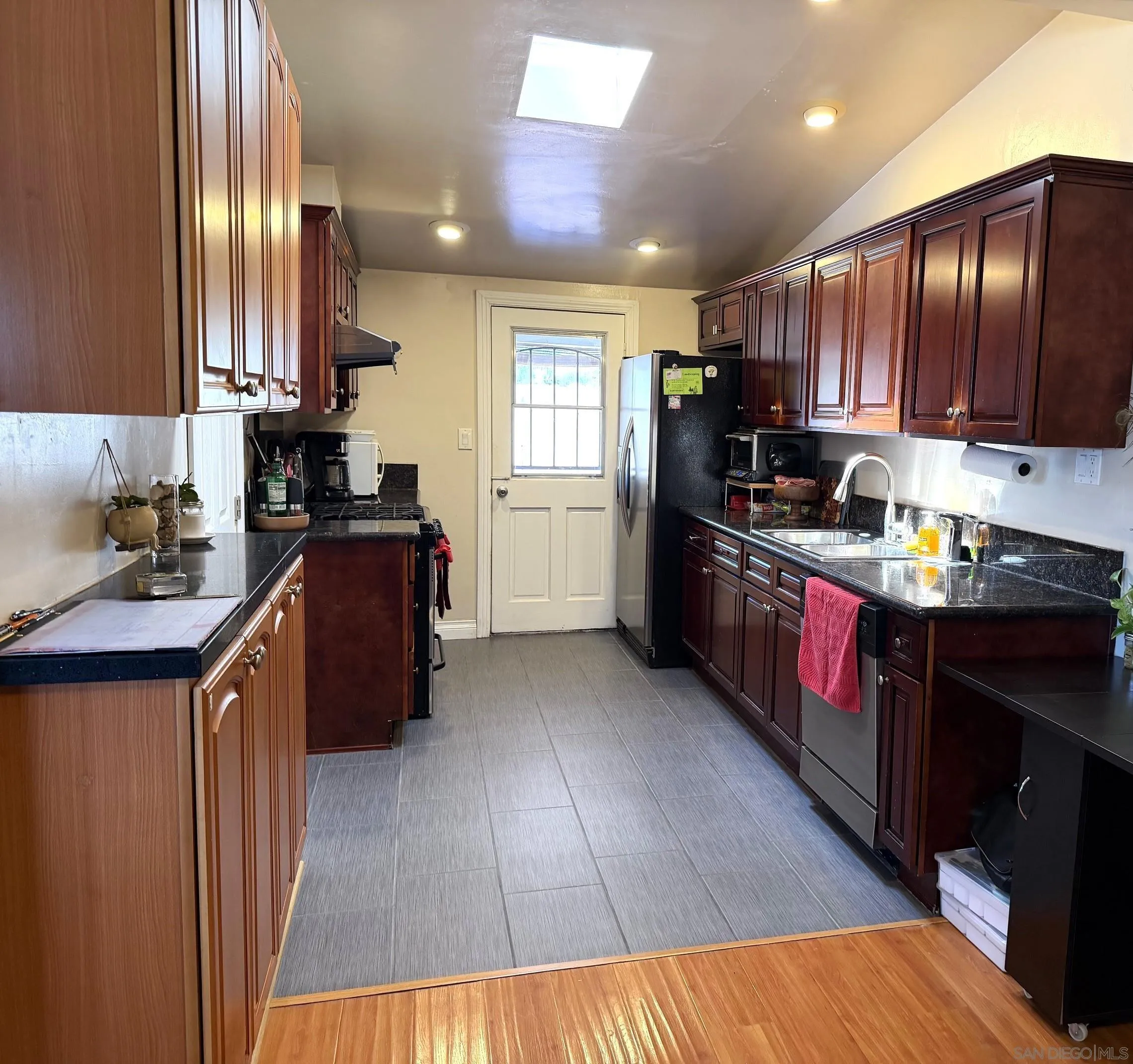 12923 Slack Street Poway, CA 92064 - Photo 10 of 29 a kitchen with granite countertop wooden floors stainless steel appliances a sink cabinets and a window