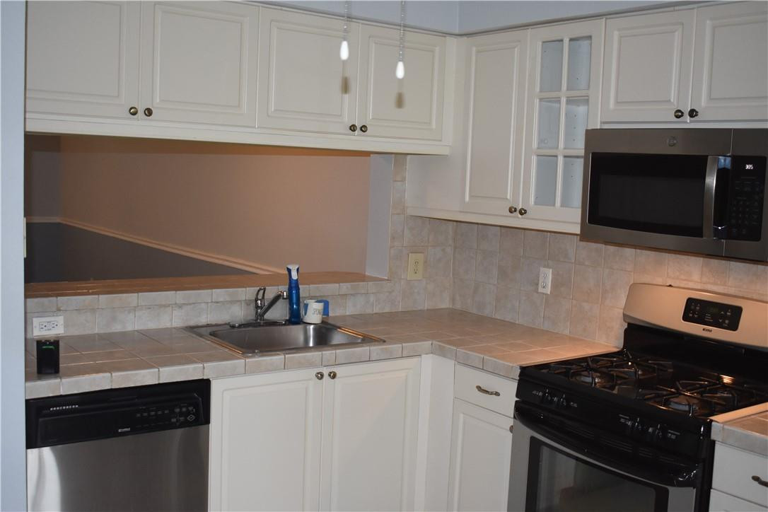 7890 Dixie Beach Circle Tamarac, FL 33321 - Photo 6 of 19 a kitchen with granite countertop white cabinets and black appliances