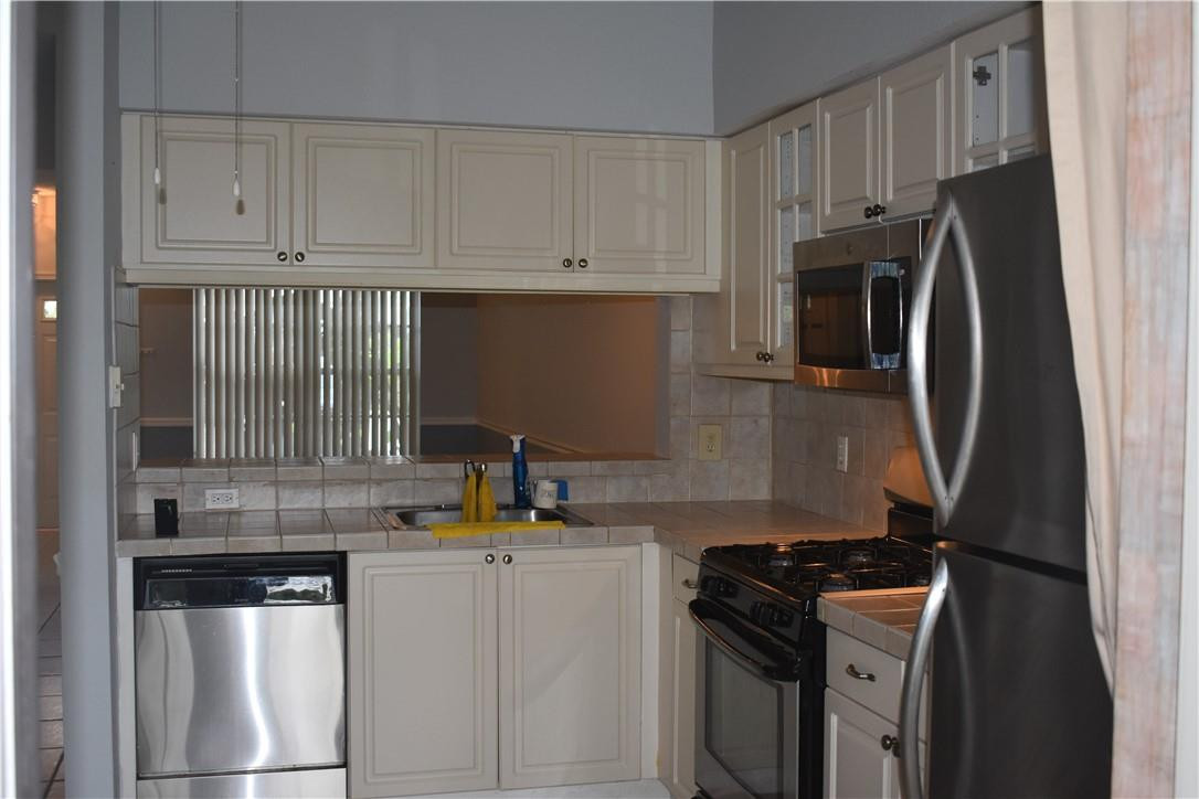 7890 Dixie Beach Circle Tamarac, FL 33321 - Photo 7 of 19 a kitchen with stainless steel appliances a stove a refrigerator and a sink