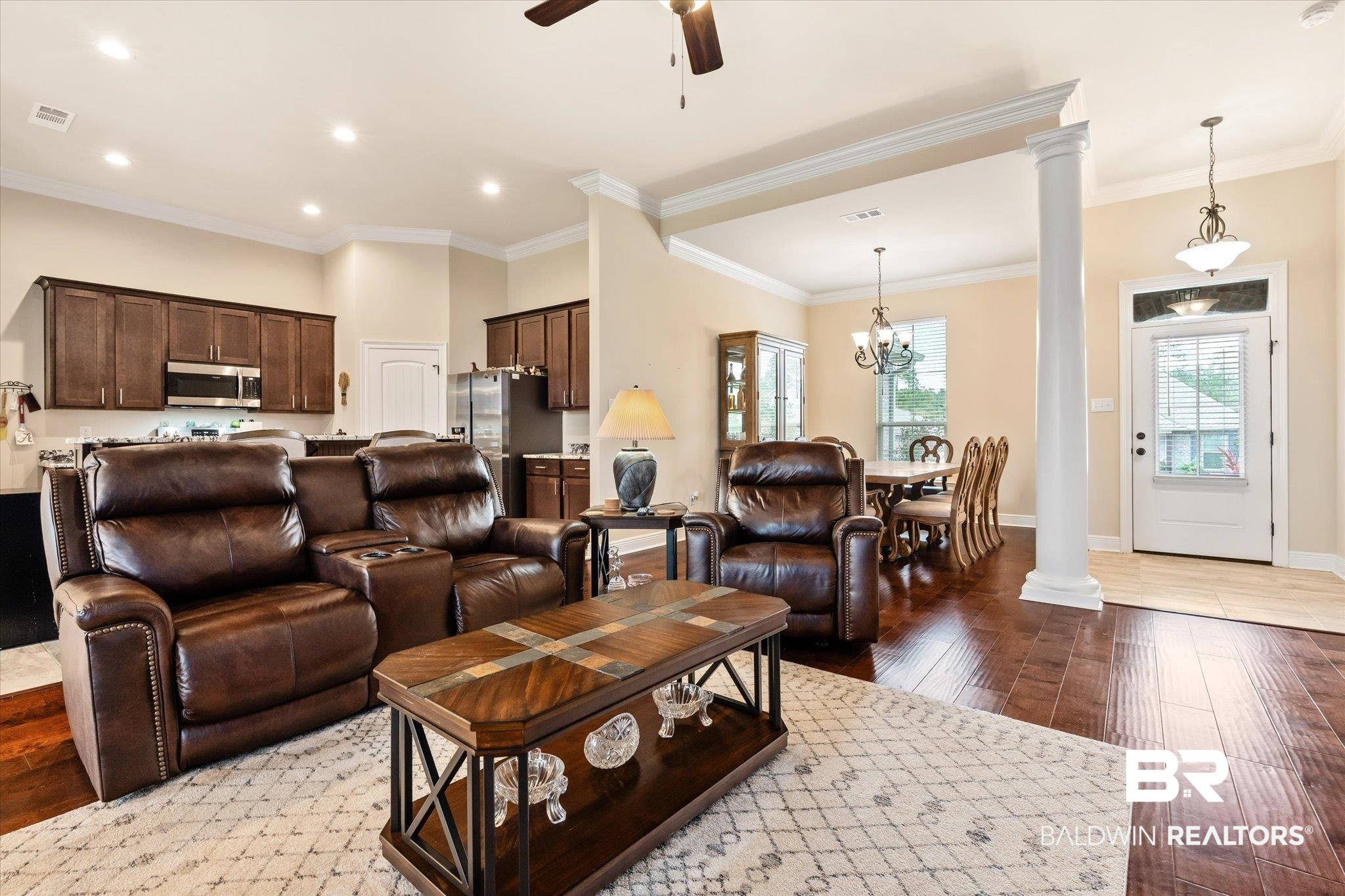 1786 Vivace Drive Foley, AL 36535 - Photo 6 of 21 Living area with dark wood finished floors, decorative columns, ceiling fan, crown molding, and a chandelier