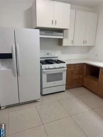 a kitchen with cabinets and white stainless steel appliances