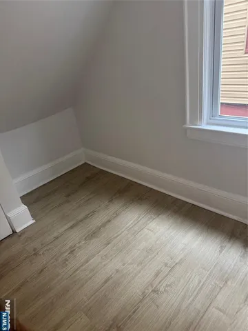 a view of a room with wooden floor and window