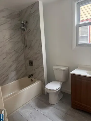 a white toilet sitting next to a bath tub