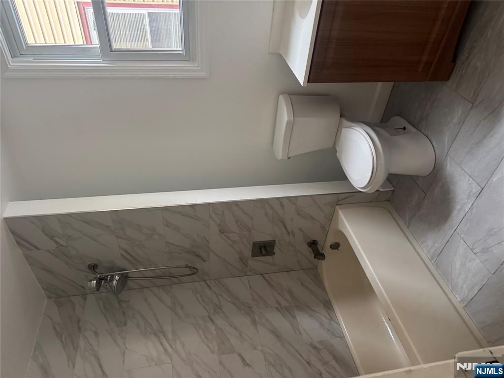 32 Jacoby Street, Unit 1 Maplewood, NJ 07040 - Photo 9 of 14 a white toilet sitting next to a bath tub
