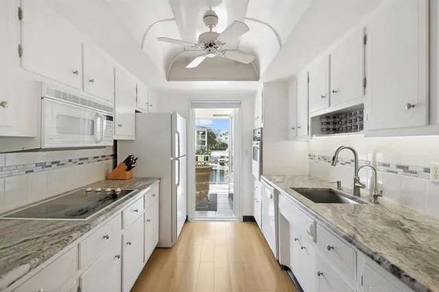 a large kitchen with stainless steel appliances granite countertop a sink and dishwasher a stove with wooden floors