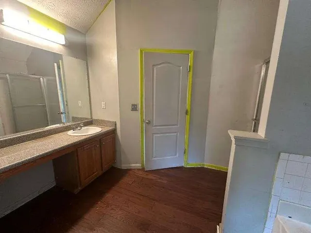 a spacious bathroom with a granite countertop sink and a mirror