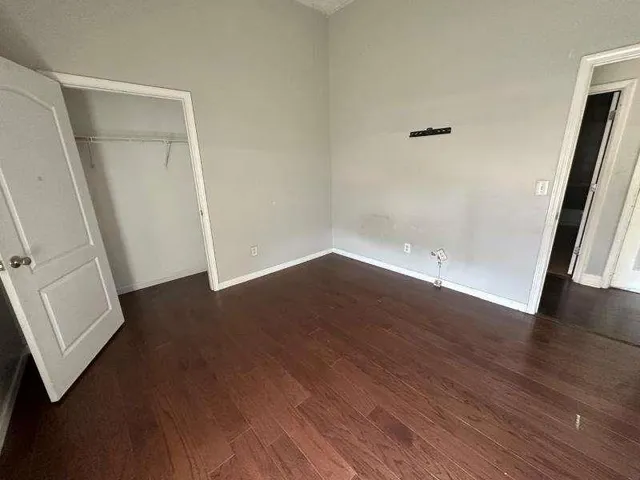 an empty room with wooden floor and entrance