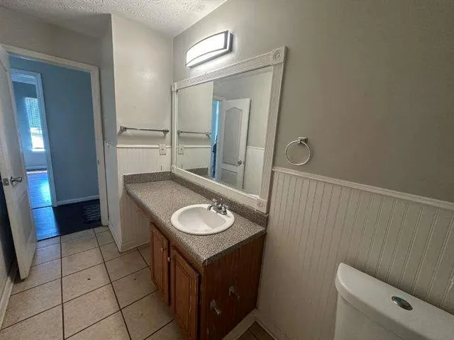 a bathroom with a sink a toilet and a mirror