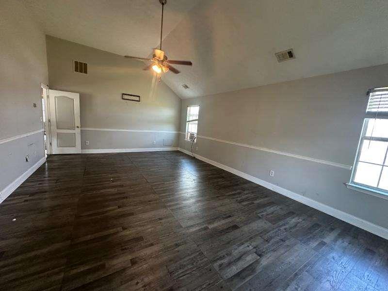 485 Brunswick Circle Stockbridge, GA 30281 - Photo 3 of 31 an empty room with wooden floor chandelier fan and windows