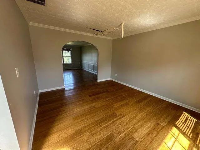 a view of empty room with wooden floor
