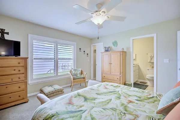a bedroom with a bed a chandelier and a television