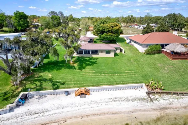 an aerial view of residential houses with outdoor space and trees