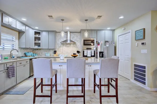 a kitchen with kitchen island wooden cabinets and stainless steel appliances