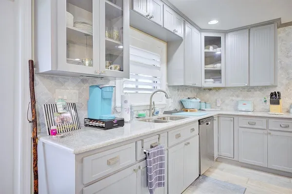 a kitchen with white cabinets and white appliances