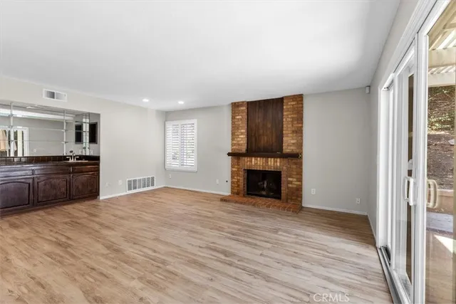 a view of an empty room with a fireplace and a window