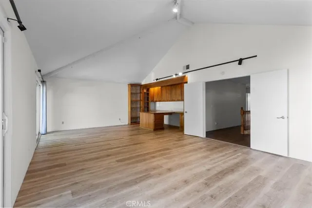 a view of empty room with wooden floor
