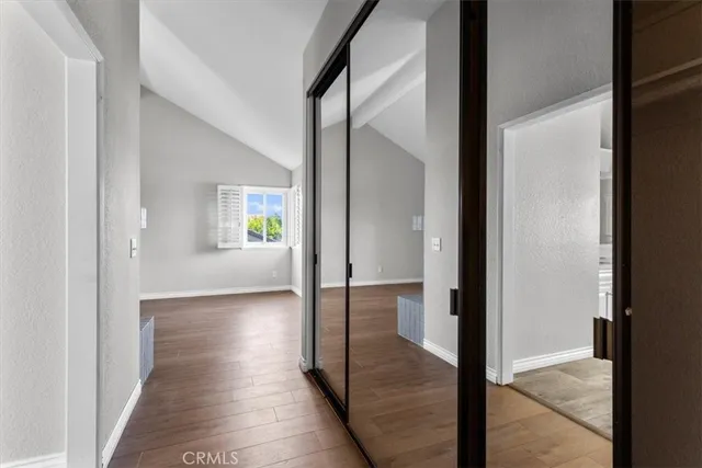 a view of a hallway with wooden floor and a living room