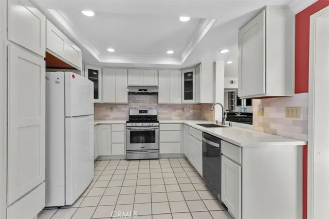a kitchen with stainless steel appliances a refrigerator sink and microwave