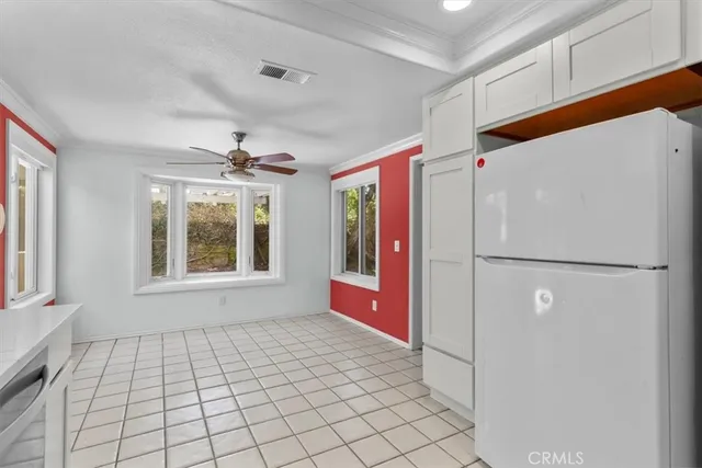 a view of an empty room with window and chandelier