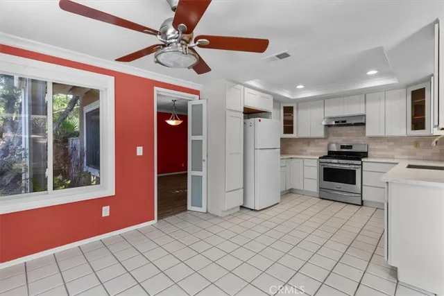 a kitchen with stainless steel appliances kitchen island granite countertop a refrigerator and a stove top oven